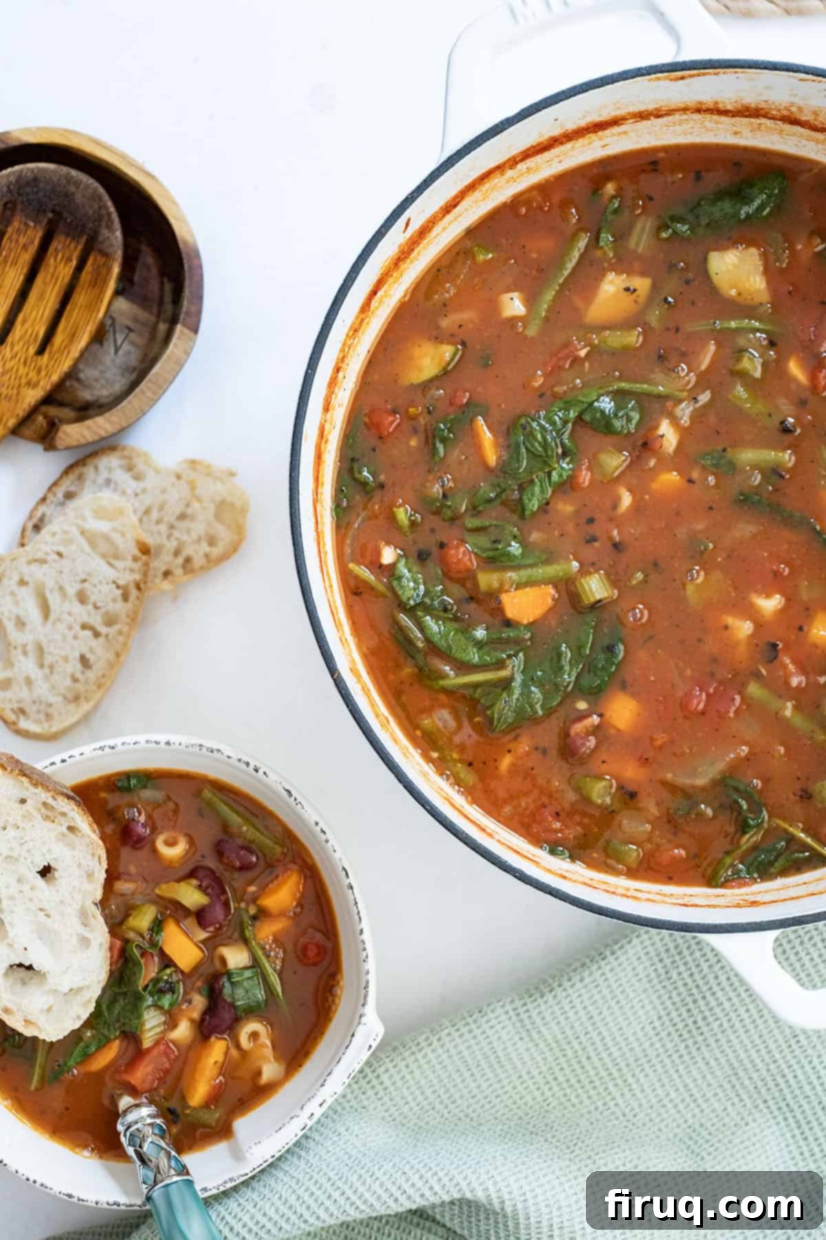 Authentic Italian Minestrone 9 A bowl of minestrone with a piece of Italian bread next to the dutch oven filled with soup.