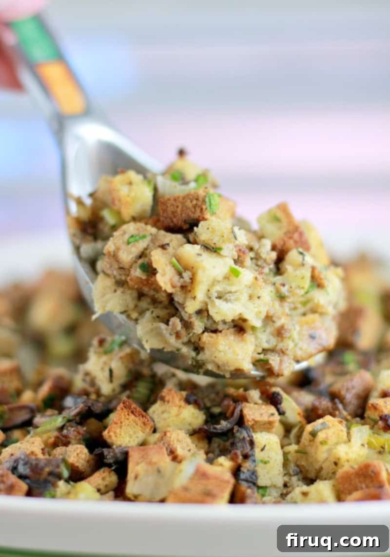 The Ultimate Holiday Stuffing 11 A large silver spoon lifting a generous scoop of perfectly cooked, golden-brown stuffing