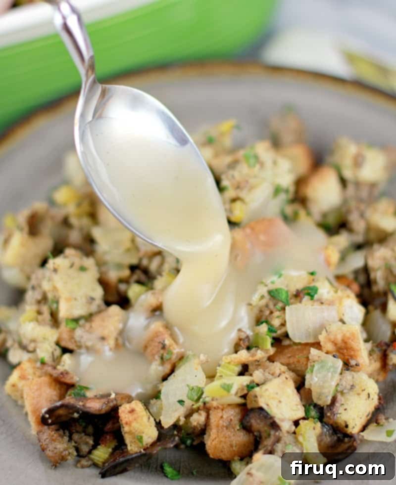 The Ultimate Holiday Stuffing 15 Plated stuffing with a spoon drizzling rich, savory gravy over the top