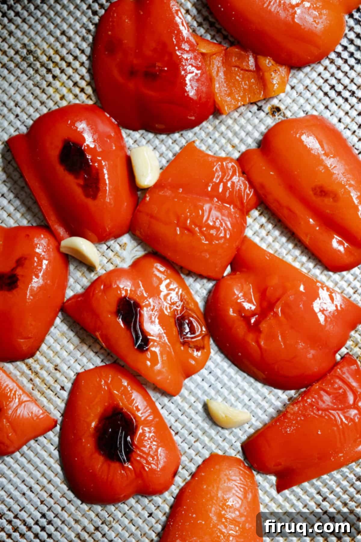 Velvety Red Pepper Sauce 4 Fresh red peppers and whole garlic cloves roasting on a baking sheet in the oven until tender and slightly charred.