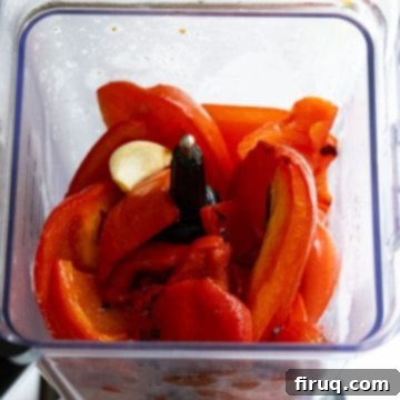 Velvety Red Pepper Sauce 8 Roasted red peppers and garlic cloves in a blender with chicken broth, ready to be processed into a smooth puree.