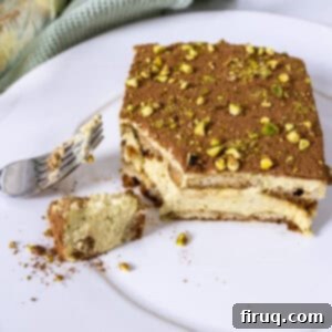 Emerald Dream Tiramisu 16 Pistachio Cream tiramisu on a plate with a forkful scooped out.