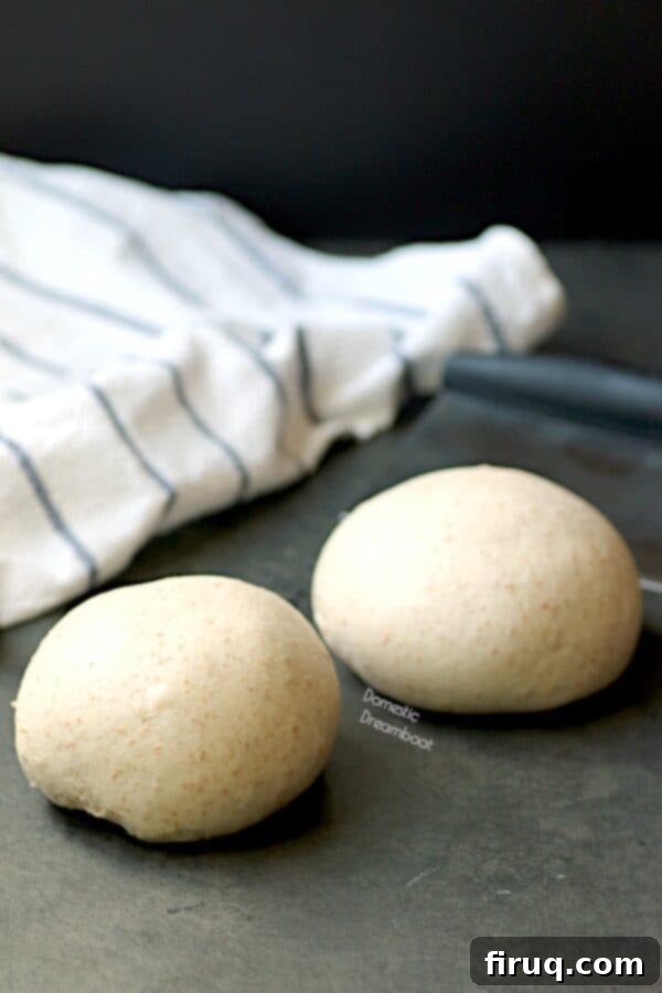 Fresh Homemade Pizza Dough Two perfectly formed balls of homemade pizza dough, ready for proofing or stretching, symbolizing the start of a delicious pizza journey.