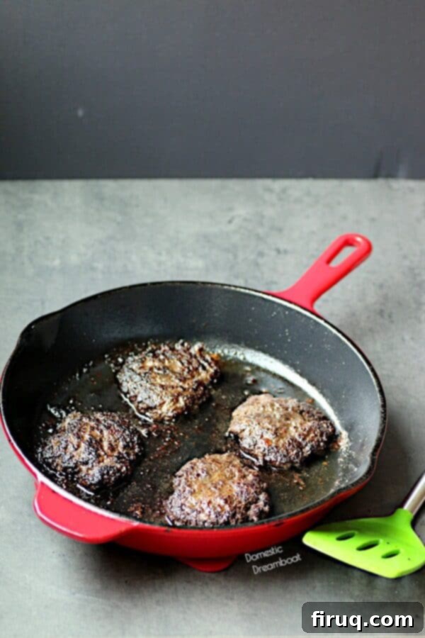 Blended Burger Patties Cooking in a Skillet Cooked hamburger patties in a skillet, showcasing the rich color of blended burgers