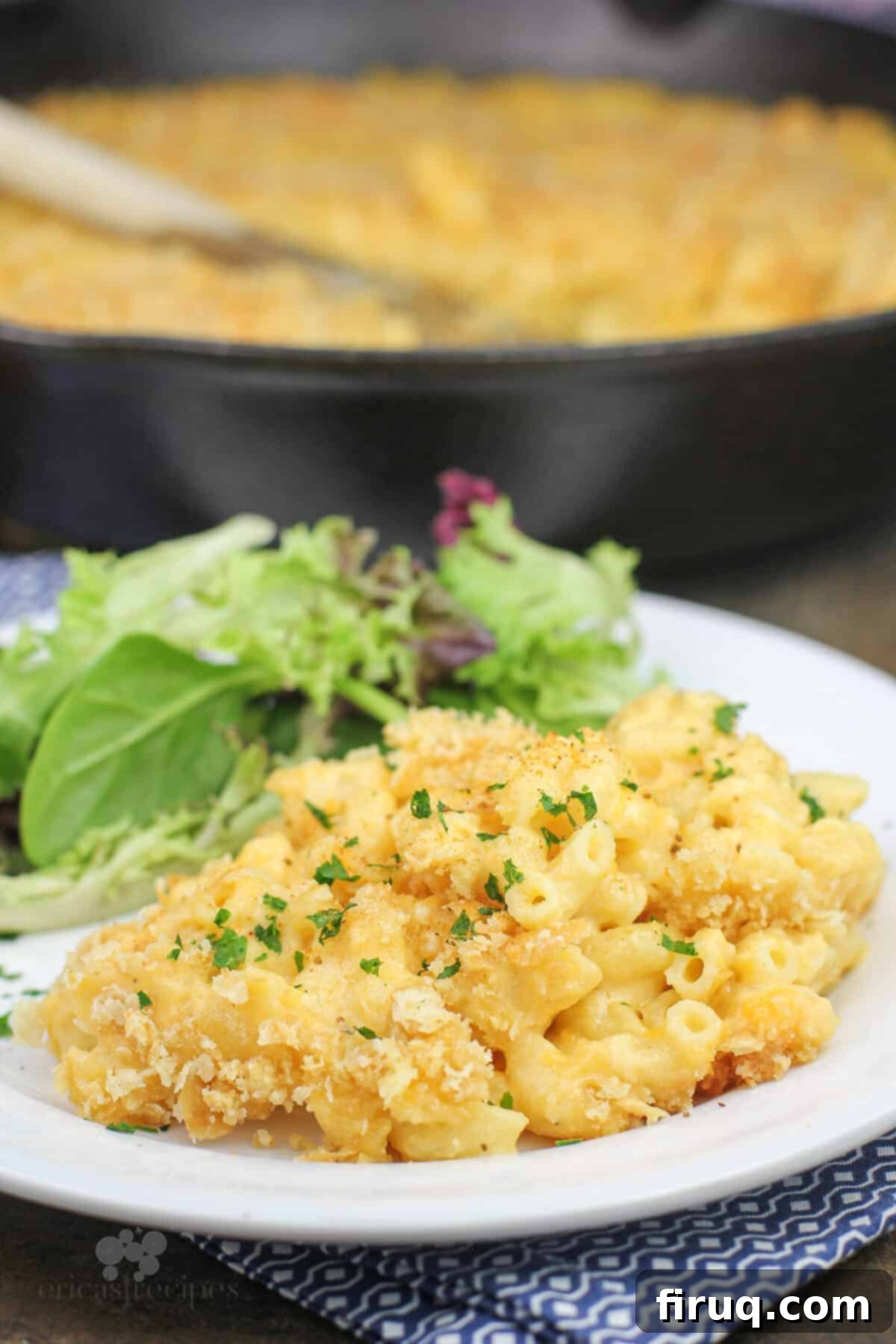 Classic Velvety Mac and Cheese 17 plated portion of macaroni and cheese, salad and skillet in background