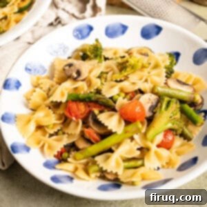 Broccoli and Asparagus Pasta Primavera 11 Pasta primavera with broccoli, asparagus, and cherry tomatoes in a bowl, garnished with parmesan.