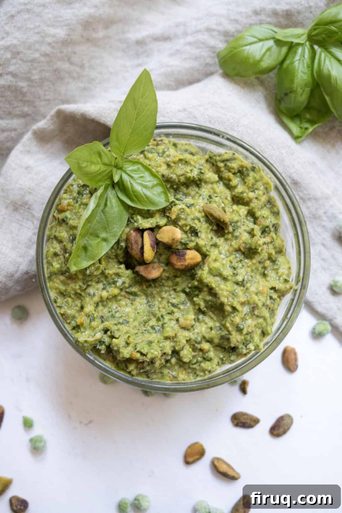 Fresh Pea Pesto 8 Pea pesto topped with pistachios and basil in a small bowl.