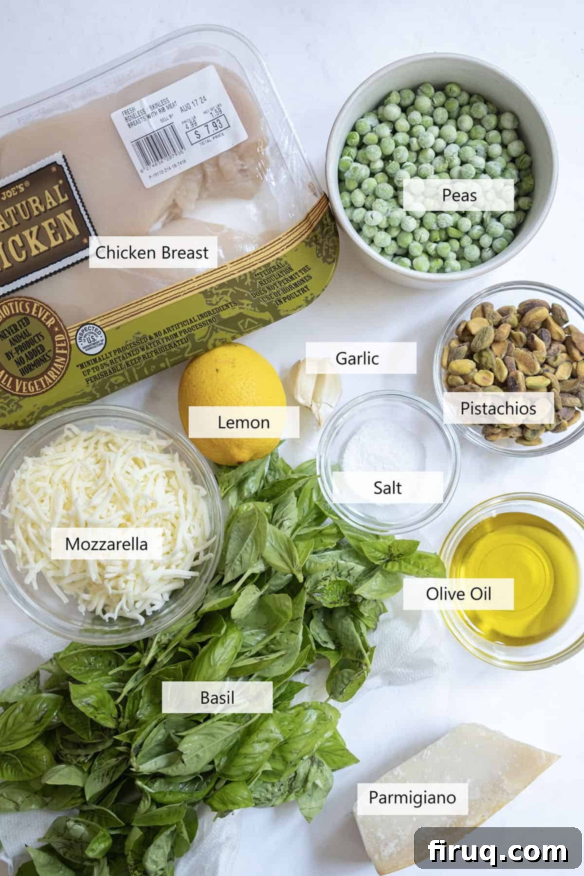 Perfect Pesto Stuffed Chicken 3 Fresh ingredients laid out for making pesto stuffed chicken, including raw chicken breasts, mozzarella cheese, vibrant green peas, fresh basil, garlic cloves, and shelled pistachios.