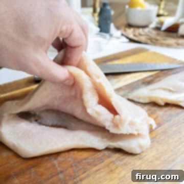Perfect Pesto Stuffed Chicken 6 A chicken breast expertly butterflied with two precise cuts, creating two distinct pockets, ready for stuffing with pesto and cheese.
