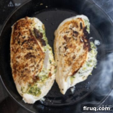 Perfect Pesto Stuffed Chicken 8 Golden-brown pesto stuffed chicken breast, perfectly seared on both sides, sizzling in a cast iron skillet on the stovetop.