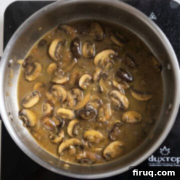 Rich Marsala Chicken with Sautéed Mushrooms 11 The Marsala sauce simmering in the pan, now thickened and light brown, after chicken has been removed.
