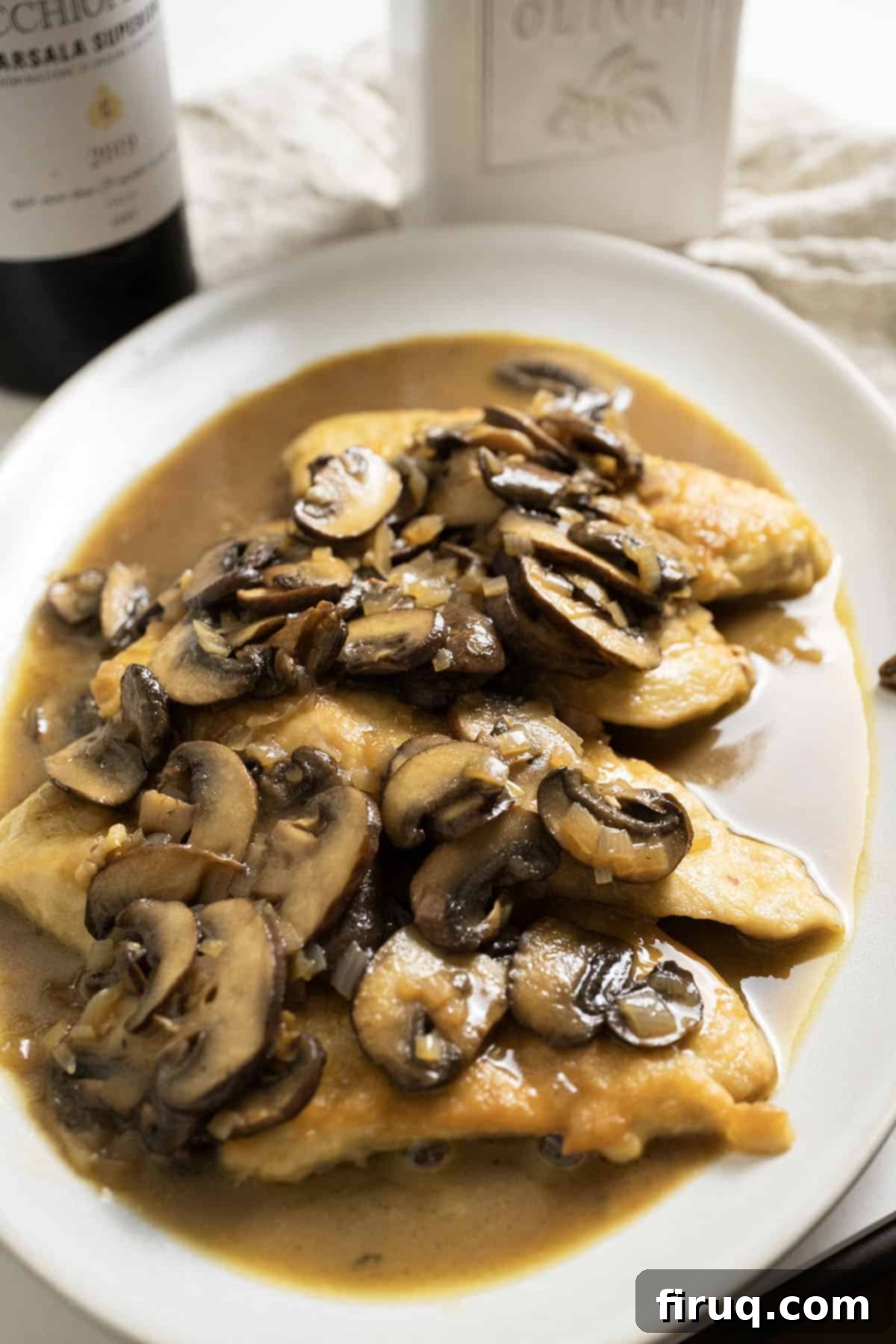 Rich Marsala Chicken with Sautéed Mushrooms 12 A plate of golden-brown chicken marsala covered in rich mushroom sauce, garnished with fresh herbs.