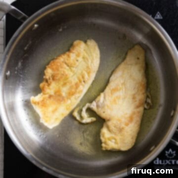 Rich Marsala Chicken with Sautéed Mushrooms 6 Chicken breasts frying in a large pan with olive oil, showing a golden brown crust.