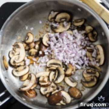 Rich Marsala Chicken with Sautéed Mushrooms 7 Mushrooms browning in a pan with freshly added minced shallots, creating flavorful brown bits on the pan's bottom.