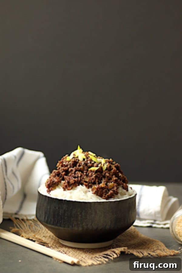 Delicious Korean Beef and Mushroom Bowl Korean beef and mushrooms over rice in a black bowl, garnished with green onions and sesame seeds.