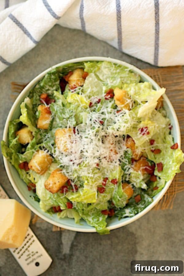 Classic Caesar Salad Presentation Overhead photo of a perfectly dressed Caesar salad with shredded Parmesan, ready to eat.