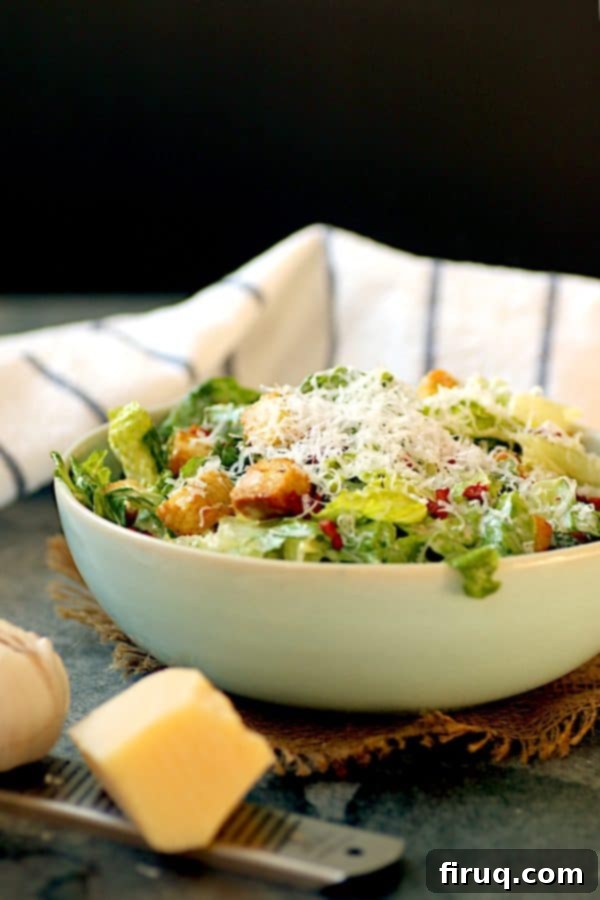 Freshly Grated Parmesan on Caesar Salad Caesar salad with a generous amount of shredded Parmesan cheese in a beautiful pale blue bowl.