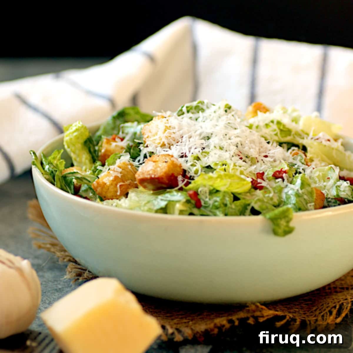 Homemade Caesar Salad Caesar salad with shredded Parmesan cheese in a pale blue bowl.