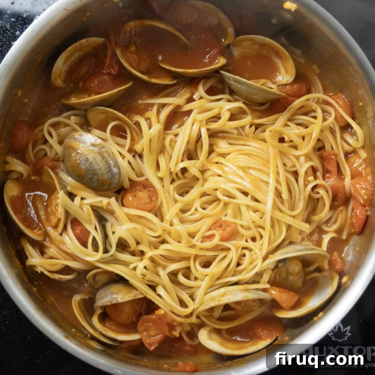Robust Red Clam Linguine 10 Al dente linguine being tossed into the vibrant red clam sauce in a large pan.