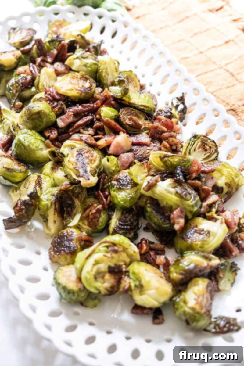 Roasted Maple Bacon Brussels Sprouts 2 Roasted Brussels sprouts on a plate with bacon and pecans.