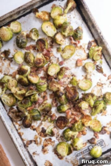 Roasted Maple Bacon Brussels Sprouts 5 Roasted brussels sprouts and bacon on a baking tray.