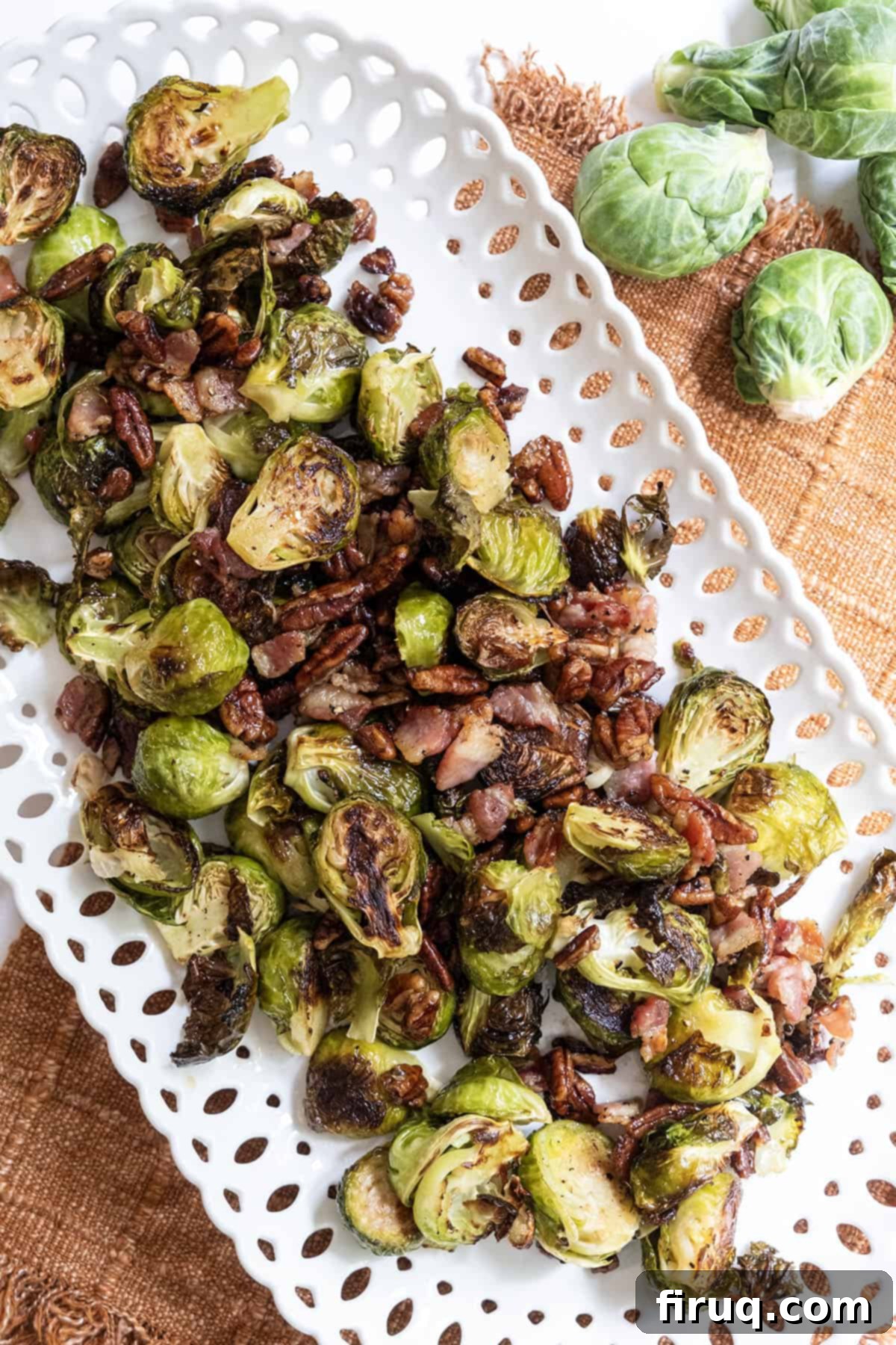 Roasted Maple Bacon Brussels Sprouts 10 Roasted Brussels sprouts on a plate with bacon and pecans.