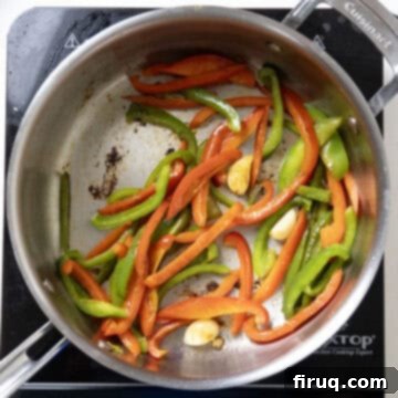 Ultimate Chicken Pizzaiola 7 Sliced bell peppers and whole garlic cloves sautéing in the same pan, developing bright colors and aromatic flavors.
