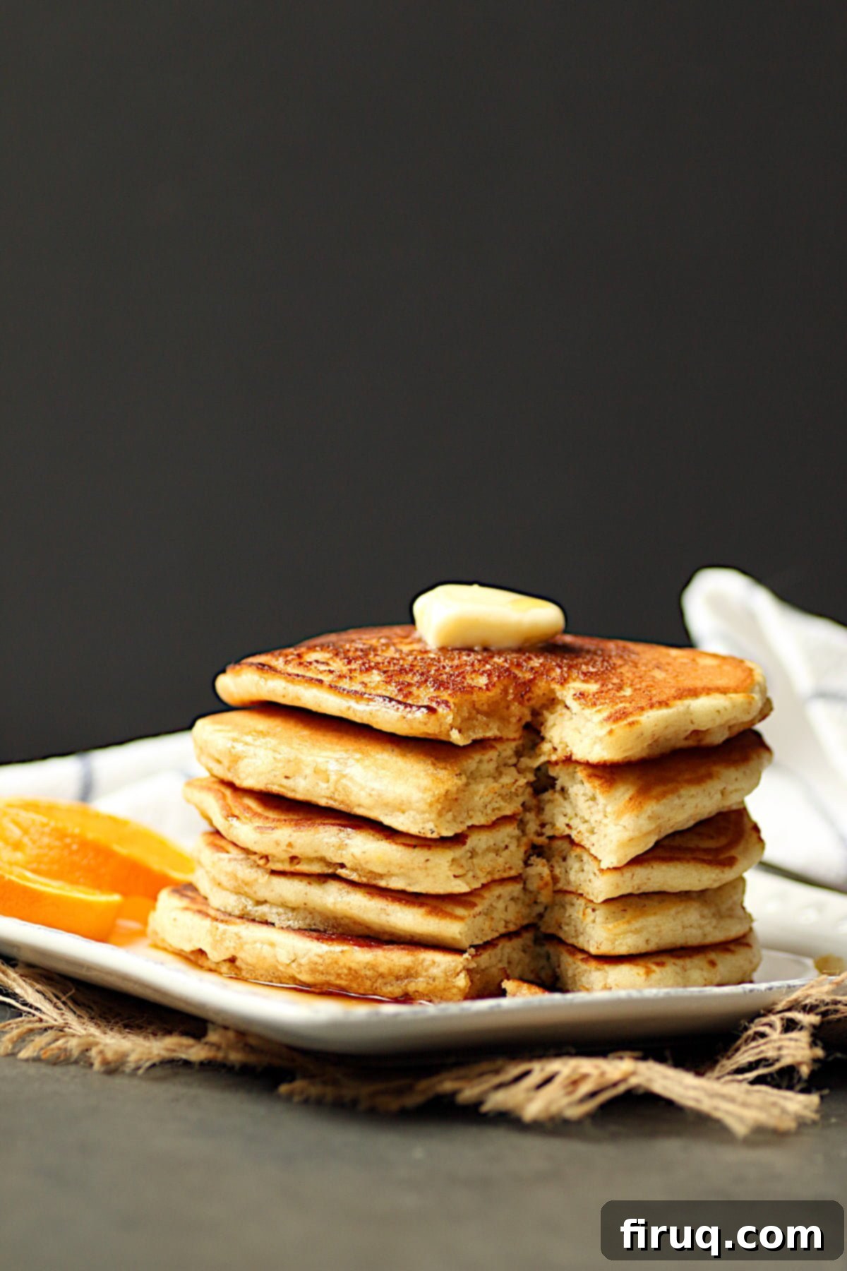 Easy Fluffy Pancakes A towering stack of incredibly fluffy pancakes with a wedge cut out, showing their airy texture.