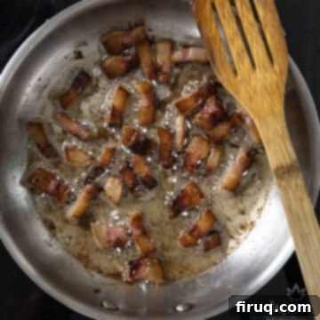 Bucatini Amatriciana 7 Perfectly golden brown and crispy guanciale sizzling gently in a saucepan, surrounded by its rendered fat.