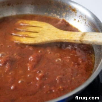 Bucatini Amatriciana 9 A rich red tomato sauce simmering gently in a saucepan, freshly seasoned with black pepper.