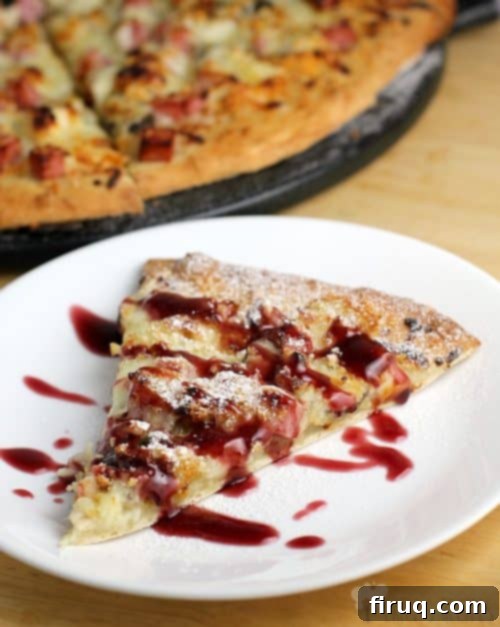 Monte Cristo Pizza 3 A hand lifting a slice of Monte Cristo Pizza, highlighting the crispy golden crust, bubbly cheese, and the unique layers of sweet and savory toppings.