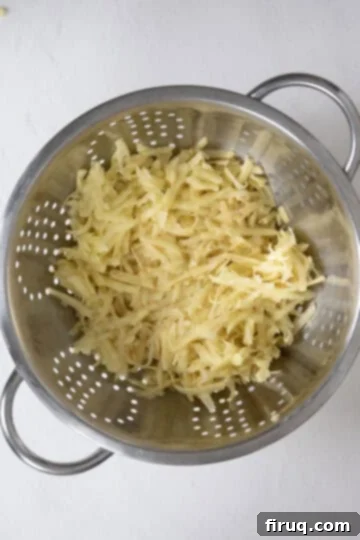 Your Italian Breakfast Sandwich 5 Grated potatoes being rinsed in a colander to remove excess starch.
