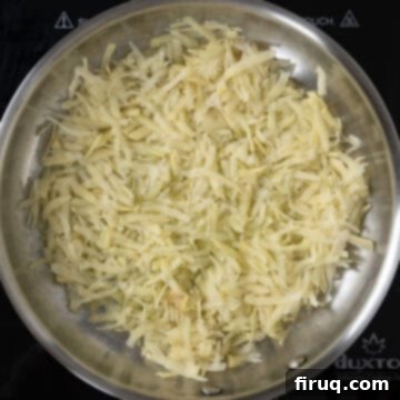 Your Italian Breakfast Sandwich 7 Hashbrowns cooking in a pan, forming a golden crust.