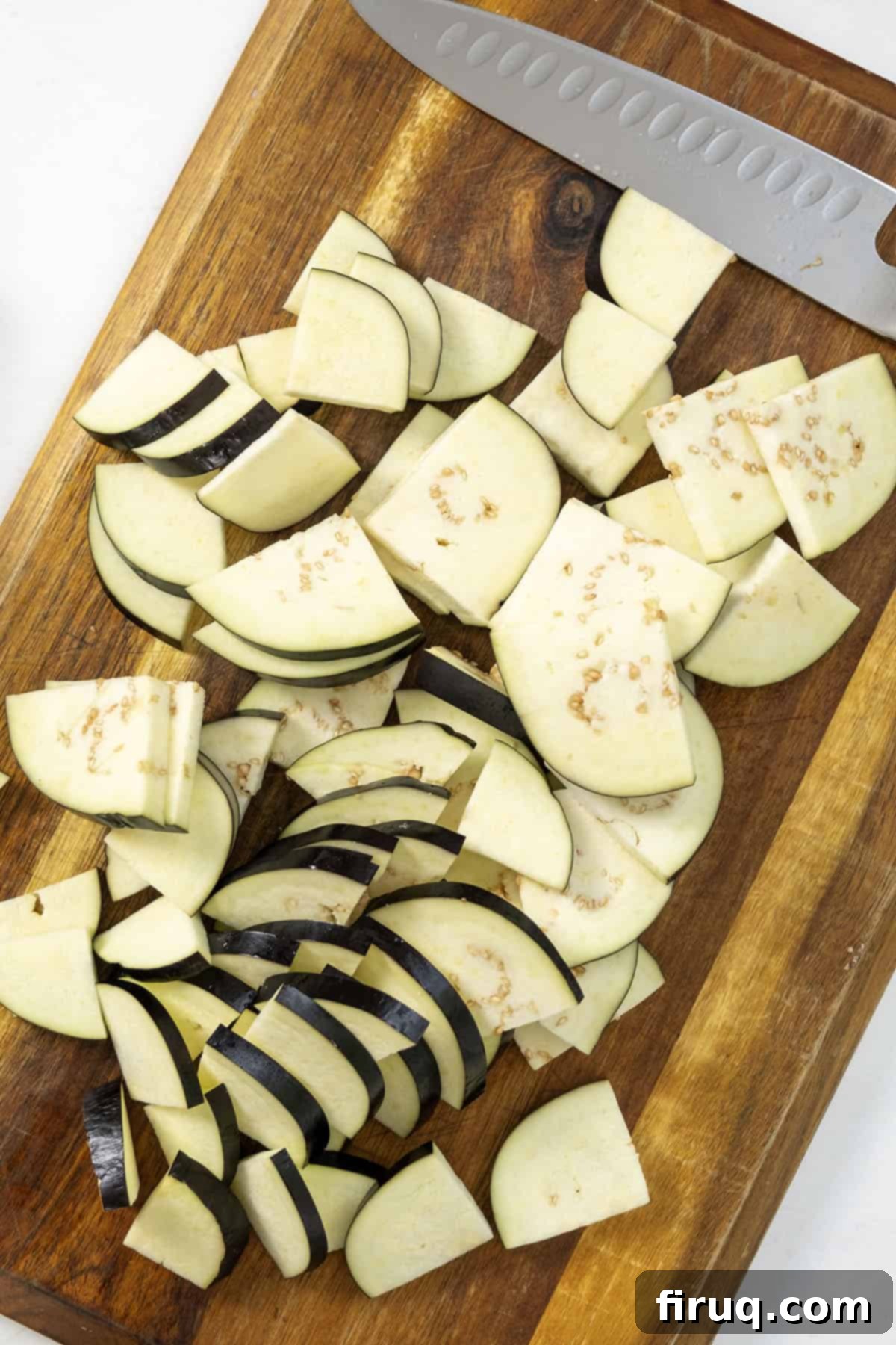 Pasta alla Norma: Sicilian Classic 4 Eggplant sliced thin and cut into quarters, lying on a cutting board.