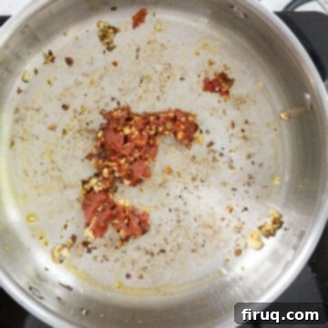 Pasta alla Norma: Sicilian Classic 7 Tomato paste caramelizing in the saucepan with garlic and seasonings.