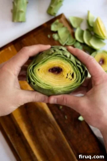 Perfectly Easy Steamed Artichokes 4 cutting off the top of an artichoke to prepare for steaming