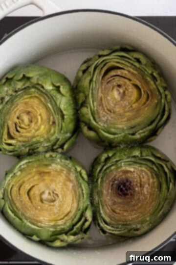 Perfectly Easy Steamed Artichokes 5 artichokes in a pot with water, olive oil, salt and pepper before steaming