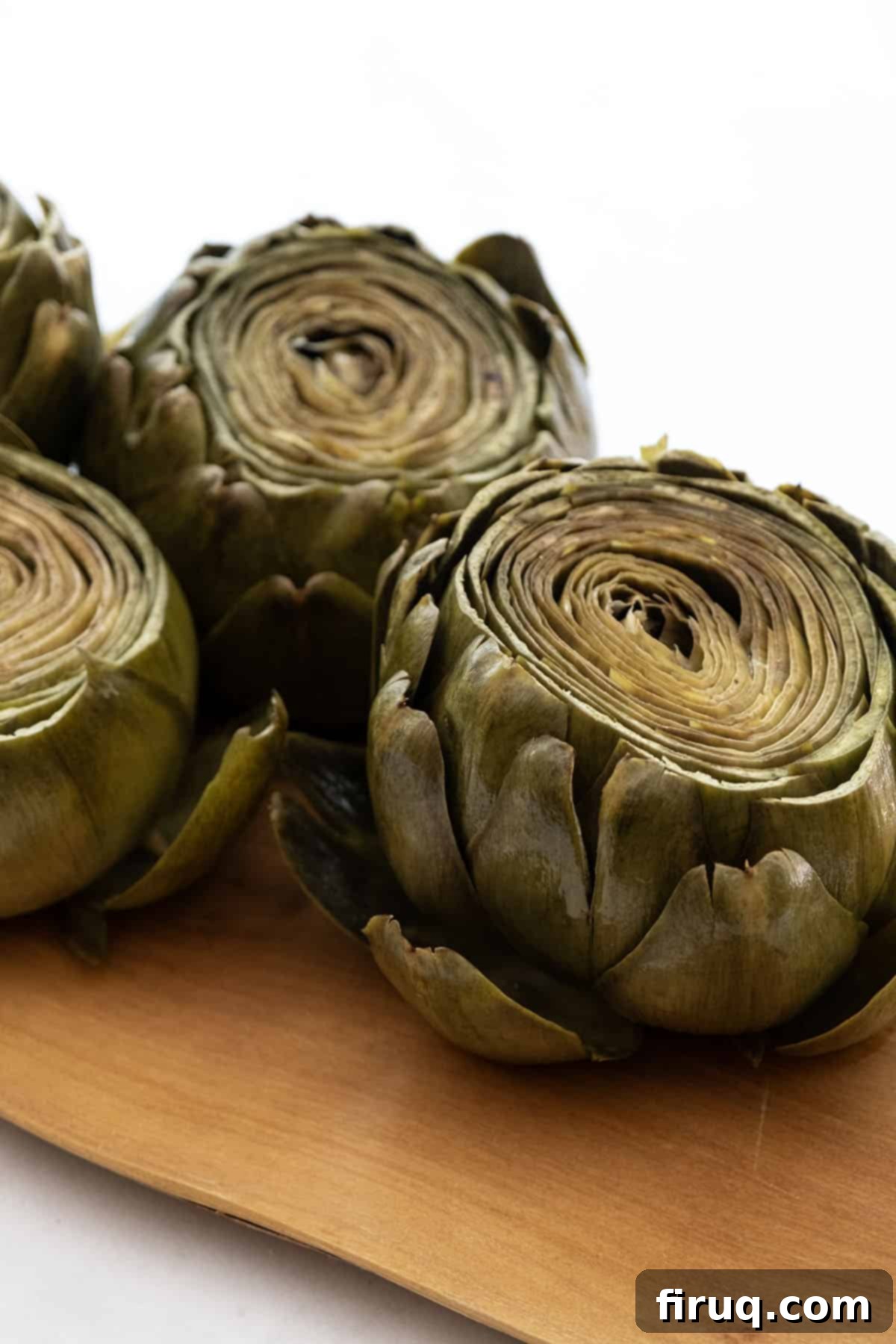 Perfectly Easy Steamed Artichokes 7 steamed artichokes served on a plate with dipping sauce