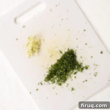 Vibrant Avocado Lime Sauce 5 Minced garlic and cilantro on a cutting board.