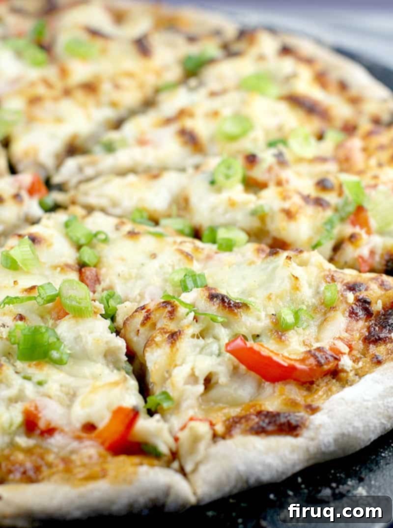 Creamy Crab Rangoon Pizza 2 sliced crab rangoon pizza on a black pizza stone