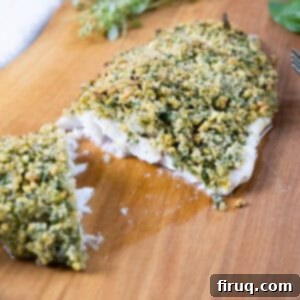 Crispy Pistachio Crusted Fish 5 pistachio crusted sea bass cut in half on a cutting board.