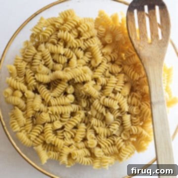 Zesty Italian Pasta Salad 5 pasta combined with olive oil in a bowl.