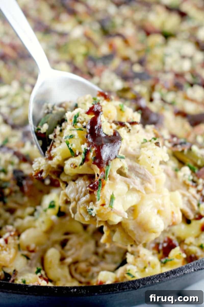 Hearty Pulled Pork Macaroni and Cheese Topped with Crispy Bacon and Fresh Herbs 2 Close-up of creamy Pulled Pork Macaroni and Cheese with crispy bacon and herb topping, showing melted cheese and tender pork