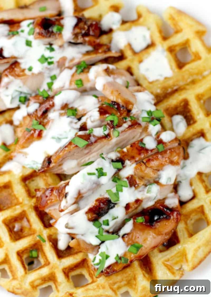 Honeyed Ale BBQ Chicken Waffle Stack 5 A serving of Honey Beer BBQ Chicken and Waffles, adorned with fresh herbs and generous drizzles of ranch and honey.