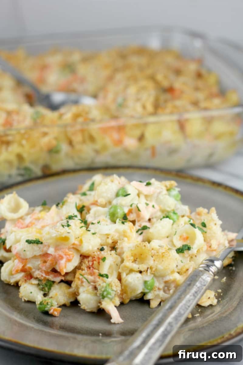 Golden Salmon Casserole 13 Two views of the cooked salmon casserole: a portion served on a plate in the foreground, and the full casserole dish in the background