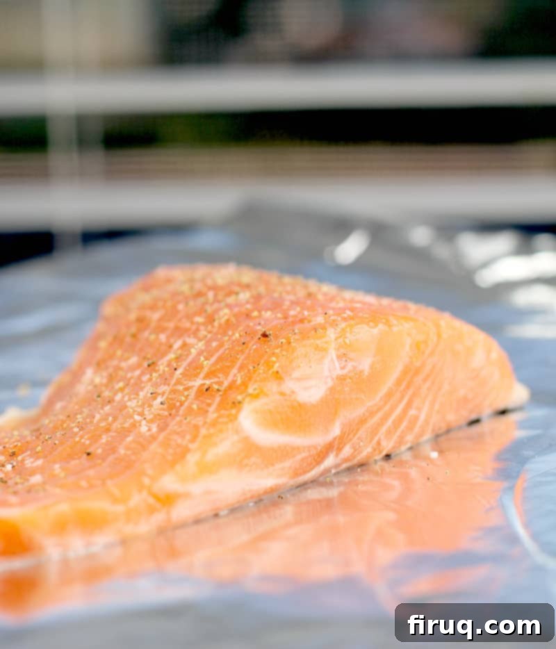 Golden Salmon Casserole 4 Raw salmon fillet seasoned with salt and pepper on a baking sheet, ready for cooking