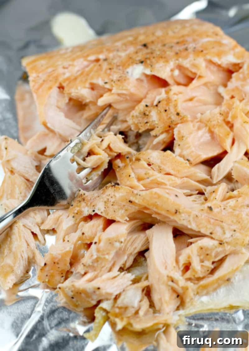 Golden Salmon Casserole 5 Flaked cooked salmon on a baking sheet with a fork, ready to be added to the casserole mixture