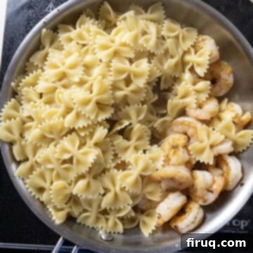 Velvety Pesto Shrimp Pasta 7 Pasta and shrimp combined in the pan.