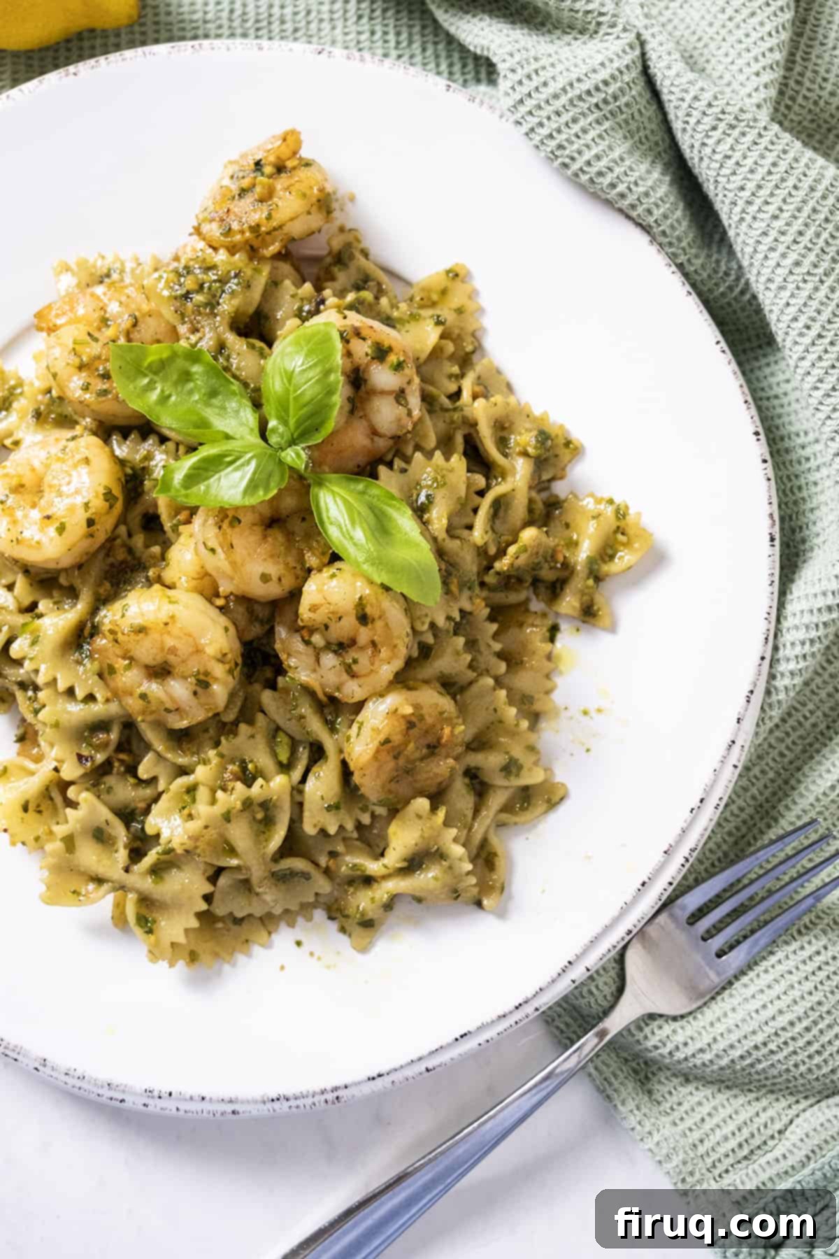 Velvety Pesto Shrimp Pasta 9 Shrimp over pesto pasta garnished with basil.