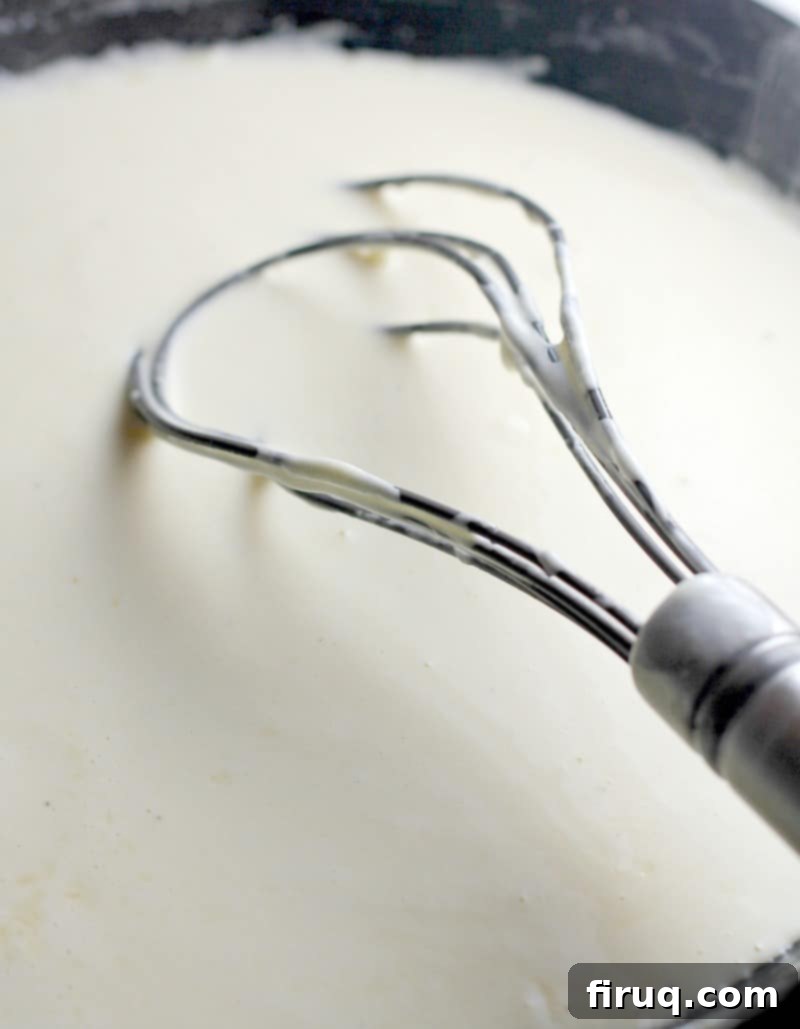 Baked Swiss Chicken Perfection 3 a whisk stirring cream sauce